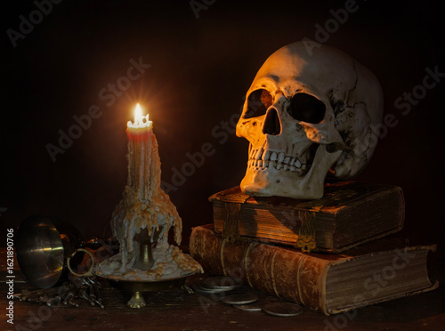 Dark Still Life with burning Candle, Skull and Antique Books. 