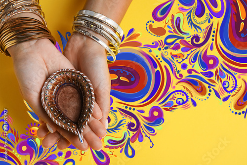 Female hands with diya lamp...