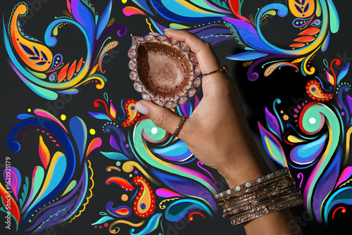 Female hand with diya lamp ...