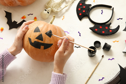 Woman painting Halloween pu...