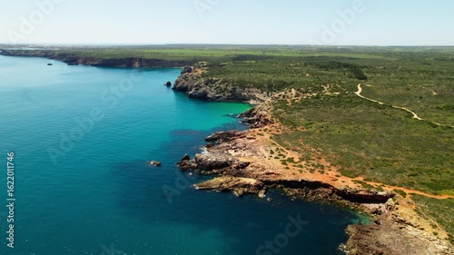 Rocky Cliffs Covered With Vegetation In Praia do Amado, Algarve Region, Portugal. Aerial Drone Shot