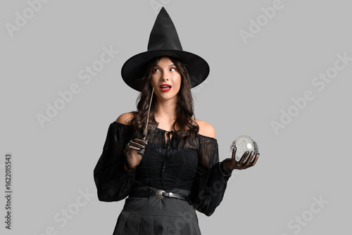 Thoughtful young witch with...