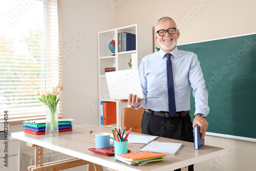 Senior male teacher with la...