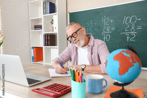 Male Math teacher writing a...