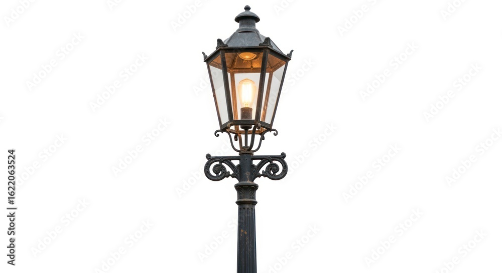 An antique black street lamp with a clear glass enclosure and a glowing bulb stands on a textured pole An antique black street lamp with a clear glass enclosure and a glowing bulb stands on a textured pole