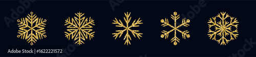 Golden glittering snowflakes on dark background. Christmas holiday decoration for greeting card and winter design.