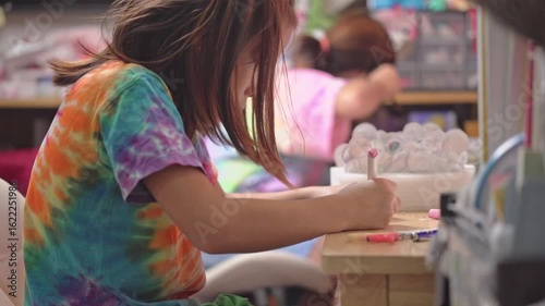 Two elementary school girls are studying at their desks at home. Two cute schoolgirls are diligently doing their homework.