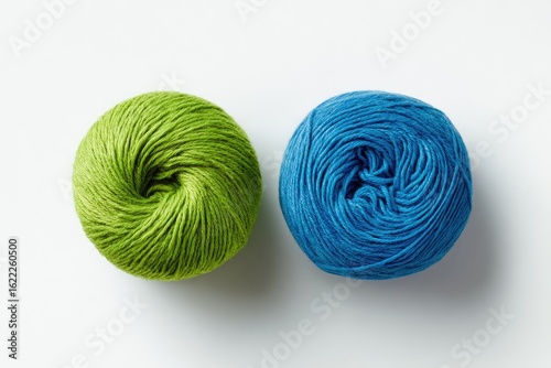 Two balls of yarn, green and blue, on white background