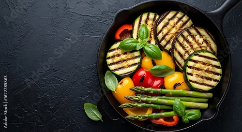 Delicious grilled vegetables including eggplant zucchini peppers and asparagus in a cast iron skillet