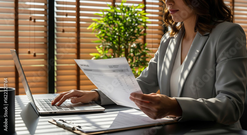 Focused Businesswoman Reviewing Financial Documents in Modern Office.
