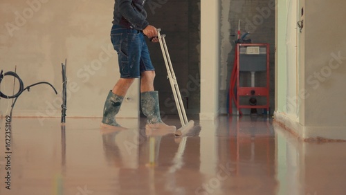 Fényképezés Construction worker smoothing concrete floor