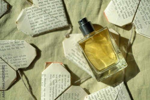 Quadro su tela perfume bottle with yellow liquid on a yellow background with paper hearts