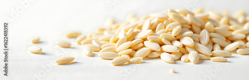 scattered white brown rice grains splayed across pristine white surface illuminated soft natural light accentuates