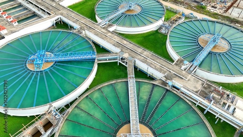 Bird's eye view of a wastewater facility showing treatment tanks that support the purification of water, critical for producing clean tap water for households and industry use.
