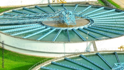 Bird's eye view of a wastewater treatment facility with circular clarifiers and rectangular filtration basins, showcasing critical infrastructure for effective water purification and community health.