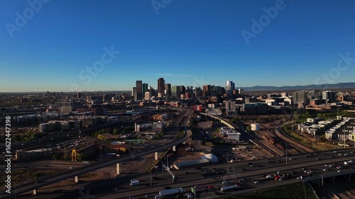 Aerial view of Denver's skyline with roads bustling with vehicles under a clear sky, a vibrant urban landscape, Denver, Denver County, United States.