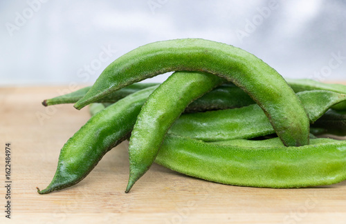 Close up of a wooden crate filled with broad beans,