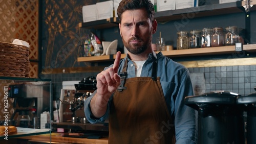 Принти на полотні Dissatisfied Caucasian man barista male waving finger warning gesture waiter emp