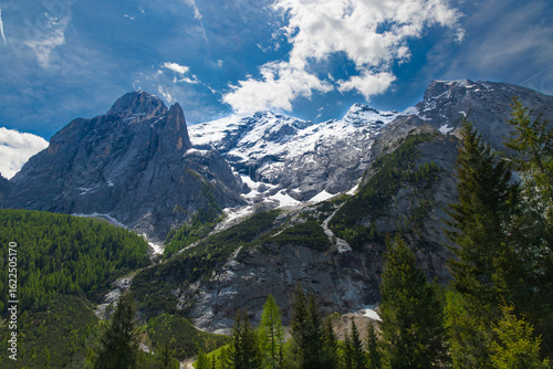 Wallpaper Mural The imposing snow-capped peaks of Marmolada, Queen of the Dolomites, stand majestically against a vibrant blue sky with scattered clouds. Torontodigital.ca