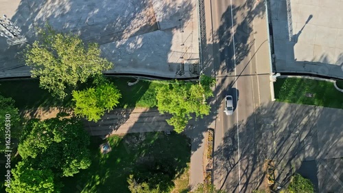 close-up aerial drone photo of the FlyBalloon in Budapest’s City Park, centered among trees, with The Private Rooftop visible in the far background under soft morning light.  