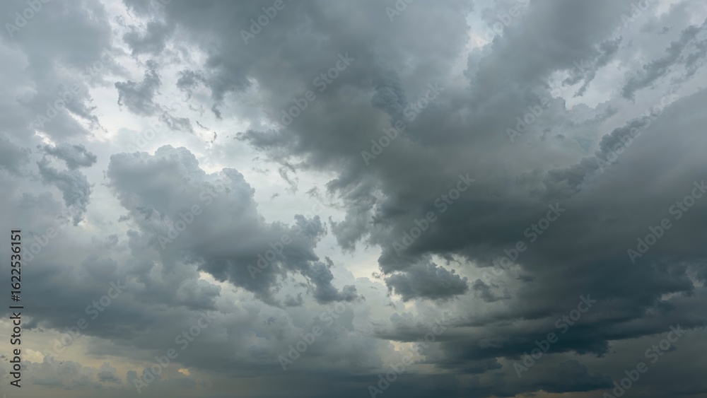 Obraz premium Wide-angle view of a cloudy sky with heavy gray clouds signaling imminent rain during the wet season.