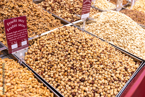 Selection of fried and roasted nuts like hazelnuts, peanuts and others offered at a market stall