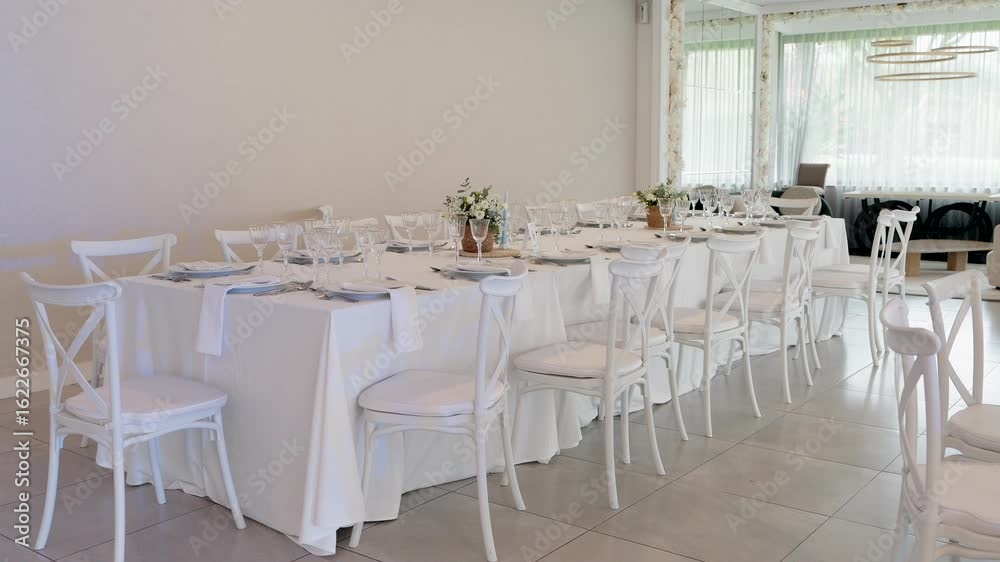 white event table with floral decor and empty chairs in soft daylight white event table with floral decor and empty chairs in soft daylight