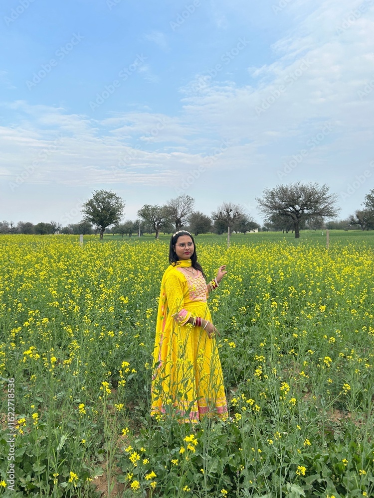 Fototapeta premium Woman in traditional attire in green field