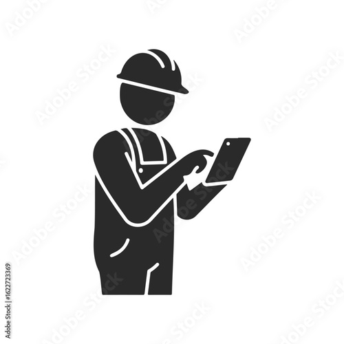 Silhouette of a construction worker using tablet in overalls and hard hat