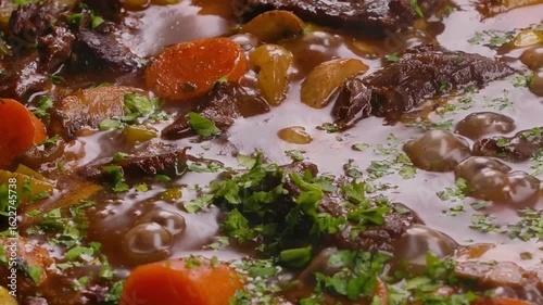 Panorama of beef pieces stewed with vegetables making beef bourguignon close up. High quality 4k footage