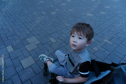 Boydark in stroller against paving slabs background