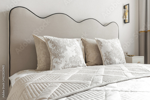 Cuadro en lienzo Elegant Bed Headboard with Decorative Pillows in Neutral Tones