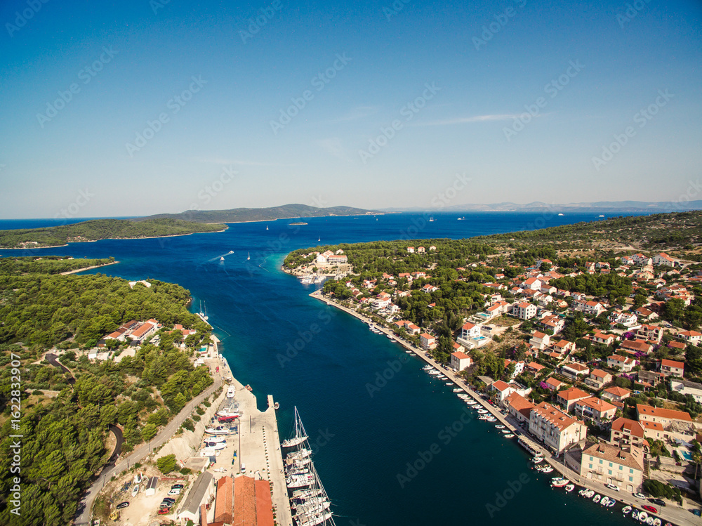 Fototapeta premium Aerial view of Milna town and marina on Brac island, Croatia, with sailboats, old stone houses, and Mediterranean landscape