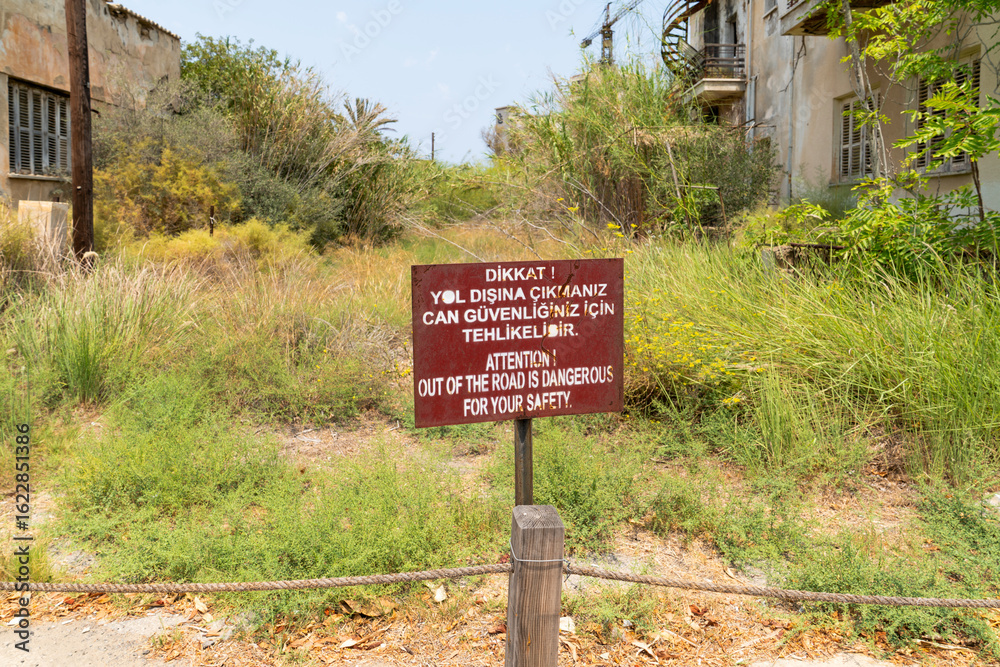 Obraz premium Warning signs such as forbidden zone, building may collapse in the abandoned city Varosha in Famagusta, North Cyprus. The local name is 