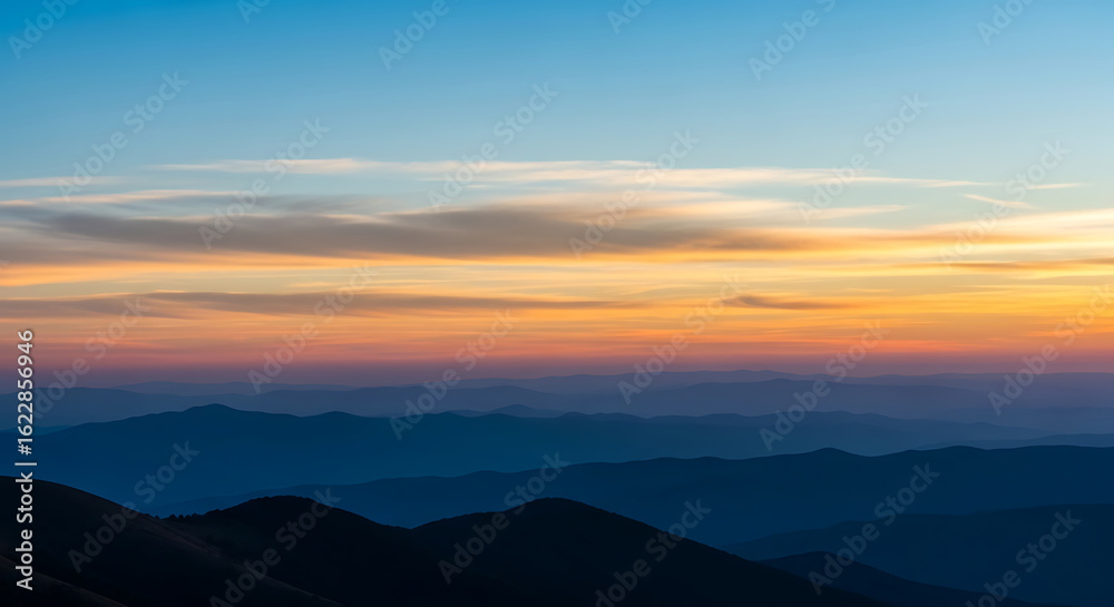 Fototapeta premium Layered mountain range silhouette at sunset with colorful sky gradient