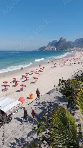 Aerial view of famous Ipanema Beach, lined with palm trees on a bright, sunny day in Rio de Janeiro, Brazil.