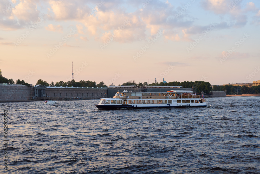 Obraz premium Enjoy a scenic boat cruise on the river, marveling at the sunset glow as day fades to night