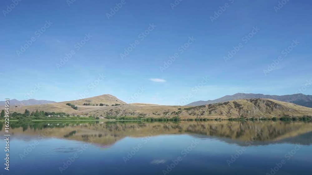 Scenic lake reflecting mountains under a clear blue sky on a sunny day Scenic lake reflecting mountains under a clear blue sky on a sunny day