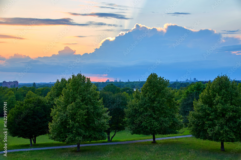 Obraz premium Der Kronsberg in Hannover ist ein beliebter Ort, um Sonnenuntergänge zu beobachten, besonders von seinem Aussichtshügel aus bietet er eine weite Panoramaaussicht.
