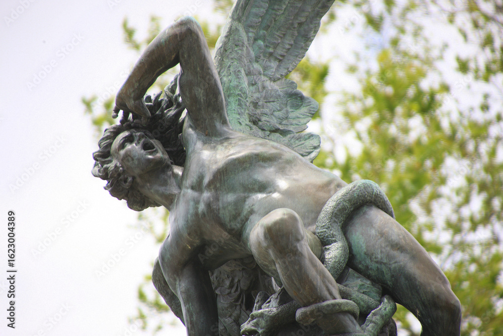 Fototapeta premium Madrid. Fountain of the Fallen Angel. The sculpture in Retiro Park (Parque del Retiro) depicts the Fallen Angel (El Ángel Caído) being expelled from paradise. (Detail)