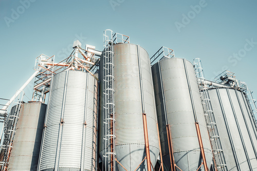 Industrial silos and machinery of a small-scale corn-based feed production plant in Campiello, Spain, with clean metal textures, bright lighting, and agricultural processing structures