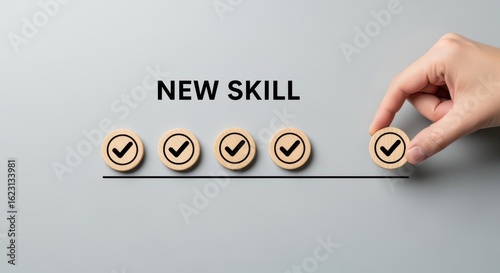 Conceptual image of acquiring a new skill with check marks on wooden tokens and hand completing the last step.