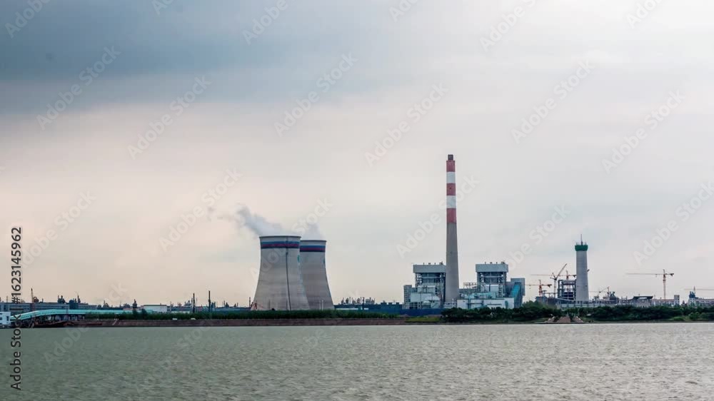 Industrial power plant with chimneys and cooling towers near water Industrial power plant with chimneys and cooling towers near water