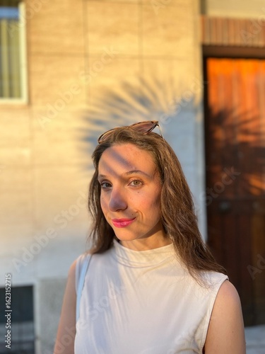 Young Female Model Portrait in Golden Hour Sunlight on her Face. Palm Tree Shadow in background
