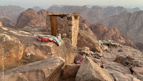 Mountain Shelter with Blankets at Sunrise Over Rocky Terrain