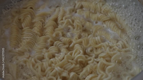Cooking instant curly noodles in boiling water. Perfect for food blogs, cooking tutorials, and restaurant menus.