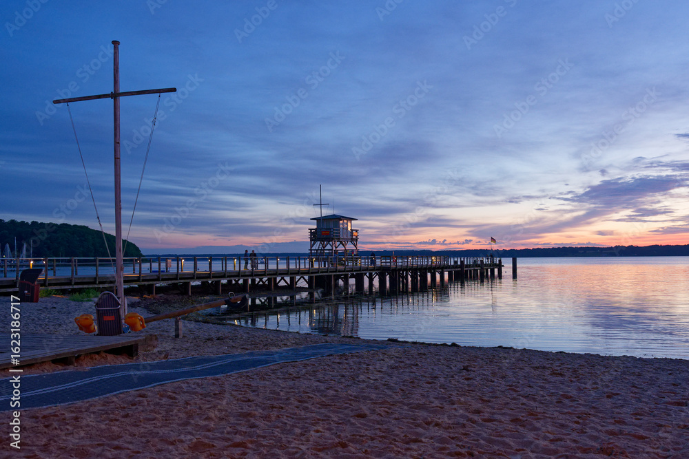 Obraz premium Seaside pier and lifeguard tower after sunset in Gluecksburg in Northern germany near Flensburg