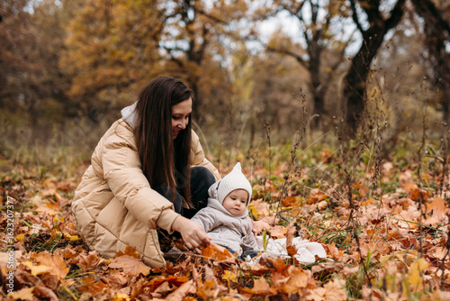 Mother and child enjoying fall in a leafy park
