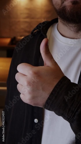 Man giving thumbs up gesture demonstrating agreement, likes, everything is fine