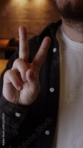 Man showing the peace and victory gesture symbolizing freedom. V sign